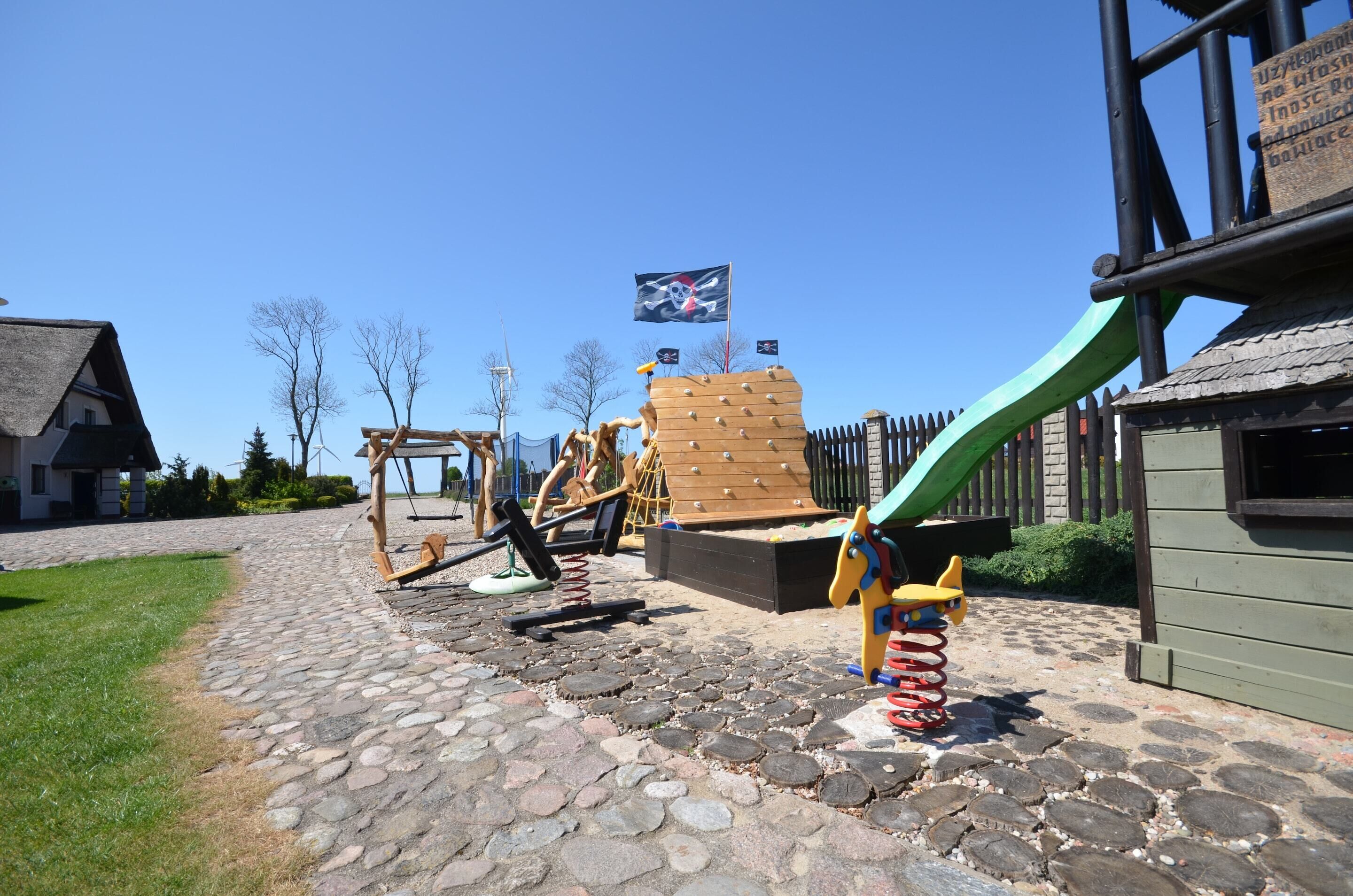 A playground with a slide, climbing structure, and swings.