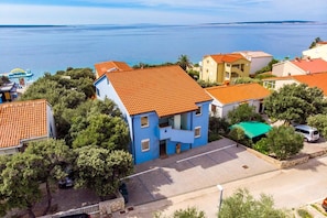 Zona residencial à beira-mar, com casas, uma rua pavimentada e vista para o oceano.
