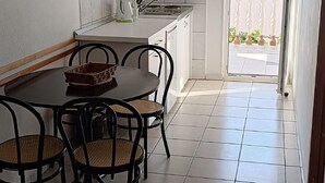 A kitchen with a dining table and chairs, a kettle, and a sink. - Comforting Holiday Home in Okrug Gornji near Sea Beach (Okrug)