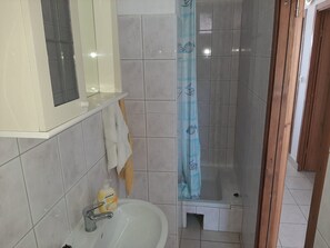 A bathroom with a white sink, a mirror, and a shower with a blue curtain. - Comfortable Holiday Home in Okrug Gornji (Okrug)