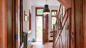 A wooden hallway with a radiator, a hanging light fixture, and a door leading to a balcony. - Splendid Villa in Vorsen (Gingelom)