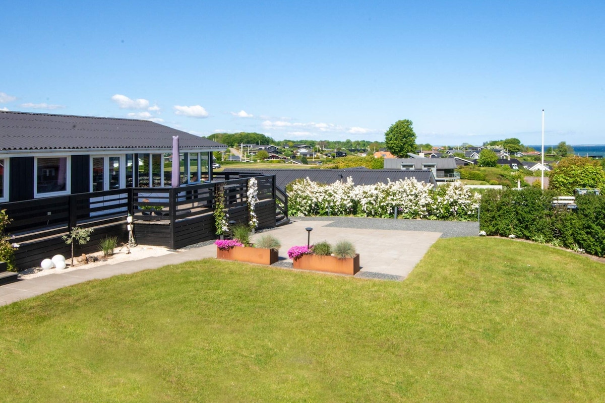 A residential area with a house featuring a covered porch and a landscaped garden.
