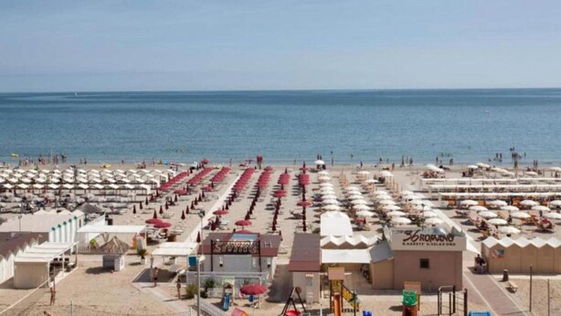 A beachside hotel with rows of beach umbrellas and sun loungers, a swimming pool, and a clear view of the sea. - Apartment in Coriano Near Vineyards & Beaches (Coriano)