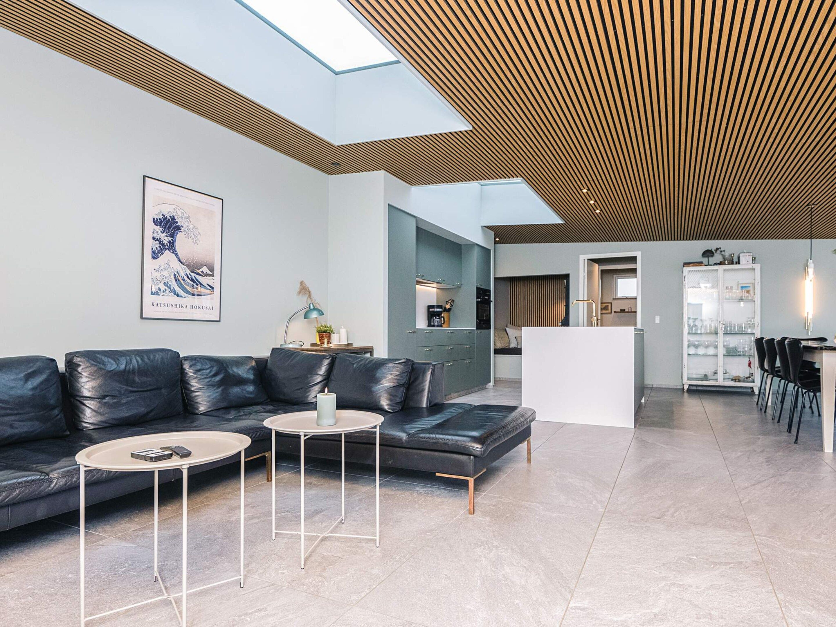 A modern living room with a sectional sofa, a coffee table, and a dining area with chairs.