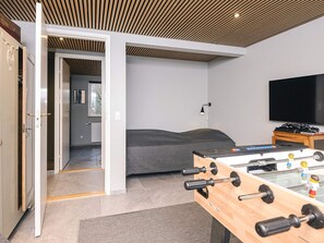 A modern room with a bed, a foosball table, and a television. - 5 Star Holiday Home in Ebeltoft (Ebeltoft)