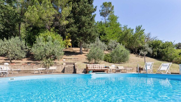 A clear blue pool with lounge chairs and a stone staircase leading to a shaded area. - Poolside Leisure in Empoli Hideaway (Empoli)