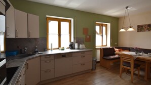 Una cucina funzionale con mobili in legno, un tavolo da pranzo e una panca.