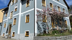 Un edificio a più piani con facciata grigia e infissi gialli.