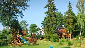 Une cabane en bois entourée d’une végétation luxuriante et d’arbres.