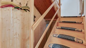 A wooden staircase with a handrail and a wooden wall with a coat rack. - Lively Holiday Home in Wien With Private Garden (Vienna)