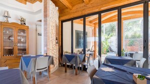 A restaurant with wooden beams, stone pillars, and large windows offering a view of the outdoors. - Apartment in Gasponi With Mountain Views (Drapia)