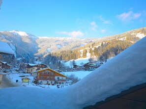 A snow-covered mountain village with traditional wooden houses and a clear blue sky. - Chalet mit Sauna und Sommergastekarte Zell am See (Zell am See)
