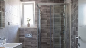 A modern bathroom with a glass-enclosed shower, a toilet, and a sink. - Plush Apartment in Imotski near Blue & Red Lakes (Imotski)