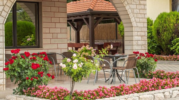 A covered outdoor seating area with brick arches, a pergola, and a table with chairs. - Plush Apartment in Imotski near Blue & Red Lakes (Imotski)