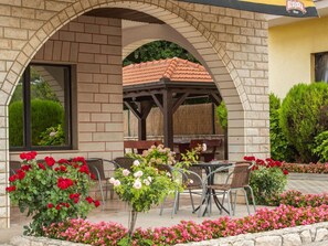 A covered outdoor seating area with brick arches, a pergola, and a table with chairs. - Plush Apartment in Imotski near Blue & Red Lakes (Imotski)
