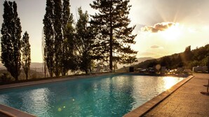 A rectangular swimming pool with clear blue water, surrounded by a pebble deck. - Belvilla by OYO Casina del Forno (Rufina)