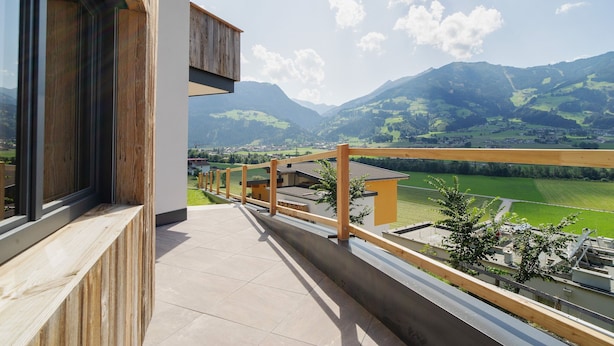 A balcony with a view of green fields and mountains. - Inviting Flat in Hart With Fitness Room (Hart im Zillertal)