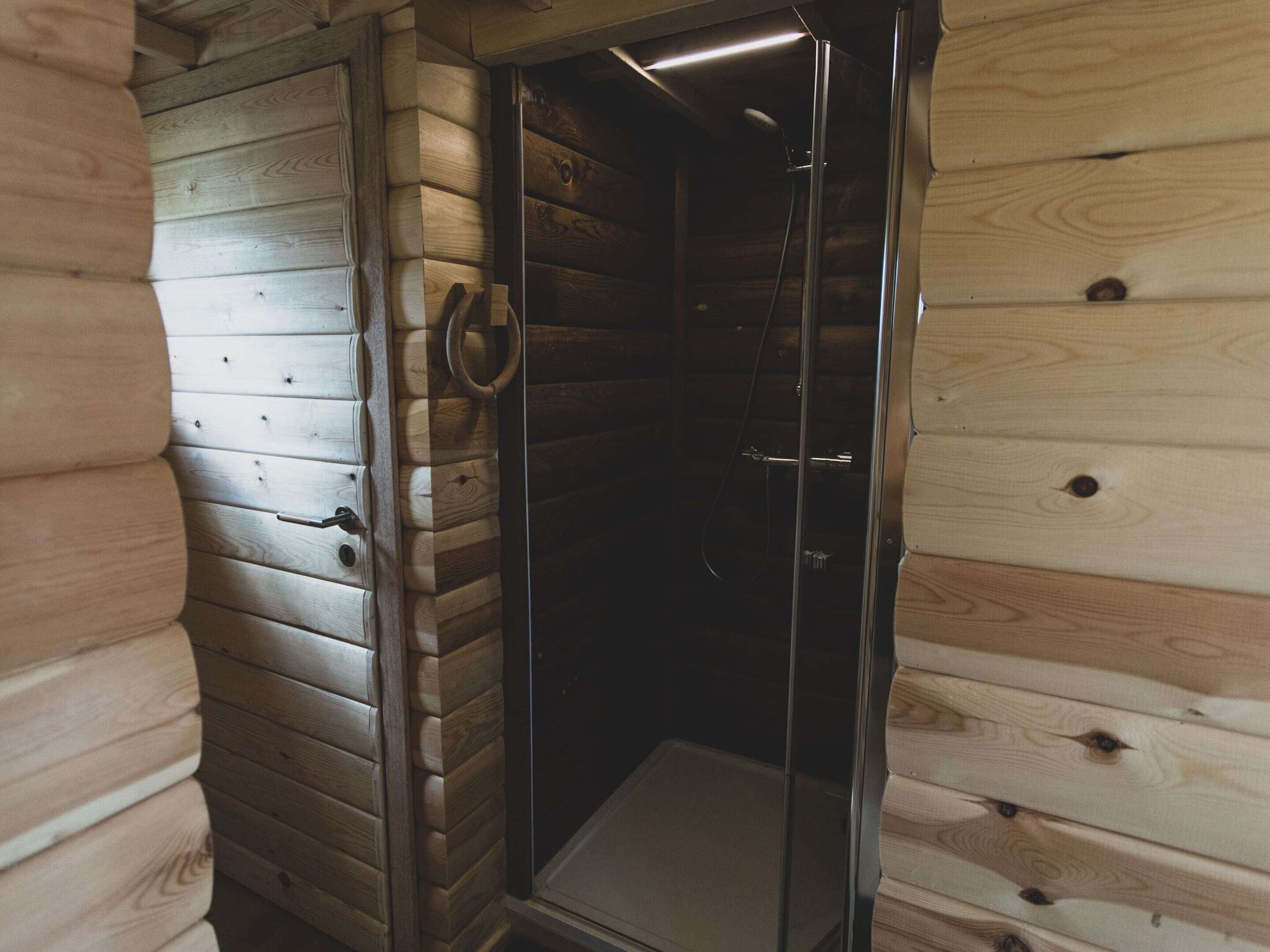 A wooden cabin with a glass-enclosed shower area.