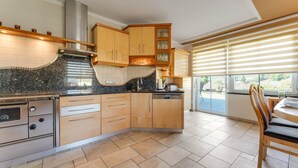 Una cocina moderna con armarios de madera, encimera de granito y horno empotrado.