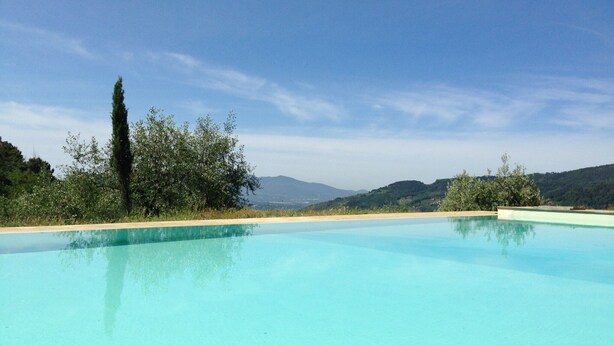 A clear blue swimming pool with a view of hills and trees in the background. - Holiday Home in Pescia With Swimming Pool (Pescia)
