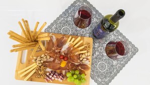 A charcuterie board with various meats, nuts, and grapes, accompanied by two glasses of red wine and a bottle of olive oil. - Apartment in Imotski Near Blue Lake (Imotski)