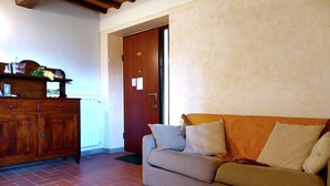 Una sala de estar con un sofá, un mueble de madera y una puerta.