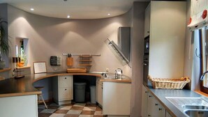 A compact kitchen with a curved countertop, a sink, and a stove.