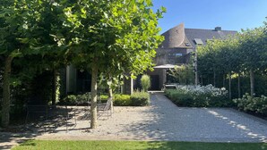 A courtyard with a gravel path, benches, and a pergola.