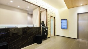 A reception area with a marble counter, a digital information board, and an elevator. - Rakuten STAY URBAN Shijo Teramachi (Kyoto)