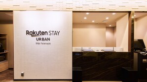 A reception area with a sign reading "Rakuten Stay URBAN" and a digital kiosk. - Rakuten STAY URBAN Shijo Teramachi (Kyoto)
