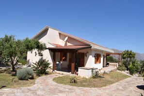 A single-story house with a patio, a satellite dish, and a view of the mountains. - Detached Villa Located in a Residential Area Near the Sea (Castellammare del Golfo)