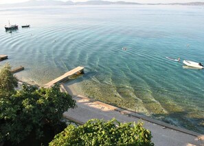 Una vista chiara su una zona con spiaggia sabbiosa, barche e un molo.