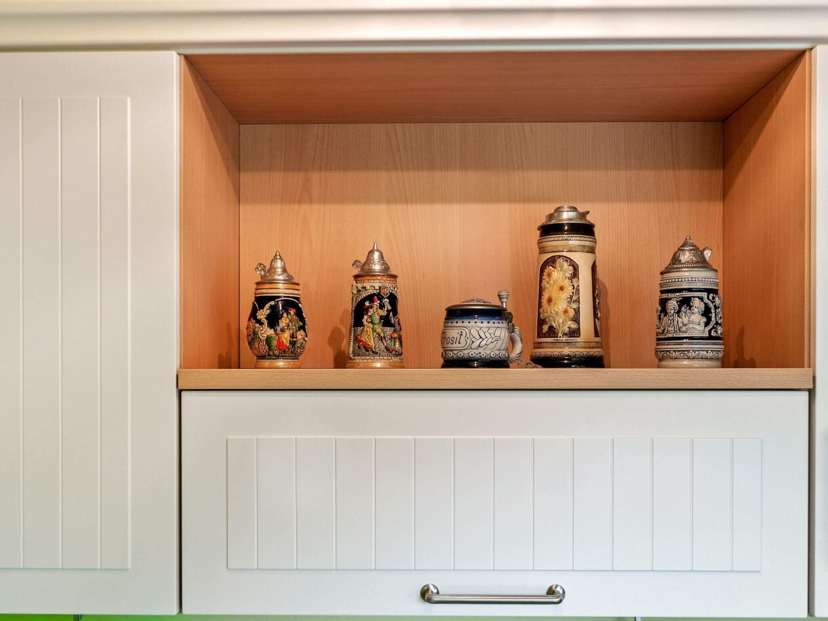 A cabinet with five decorative containers.