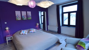 A bedroom with a large bed, two bedside tables, a window with curtains, and a view of the outside. - Pleasant Holiday Home in Herbeumont near Semois River (Herbeumont)