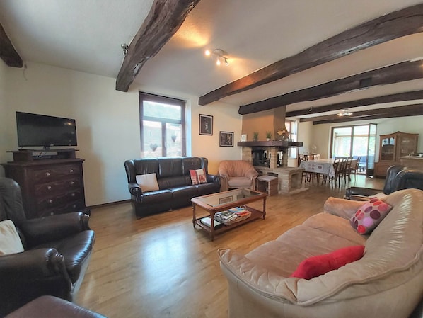 A living room with a fireplace, leather sofas, a coffee table, and a television.