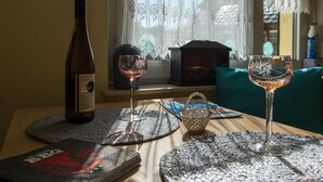 A table with a bottle of wine, two glasses, and a coaster with a logo. - Pleasant Apartment in Veckenstedt near Ilsenburg (Nordharz)