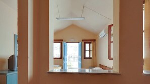 A hotel room with a bed, a desk, and a window. - Pretty Holiday Home in Symi Island With Balcony (Symi)