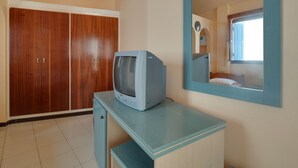 A room with a wooden wardrobe, a small desk with a television, and a mirror on the wall. - Pretty Holiday Home in Symi Island With Balcony (Symi)