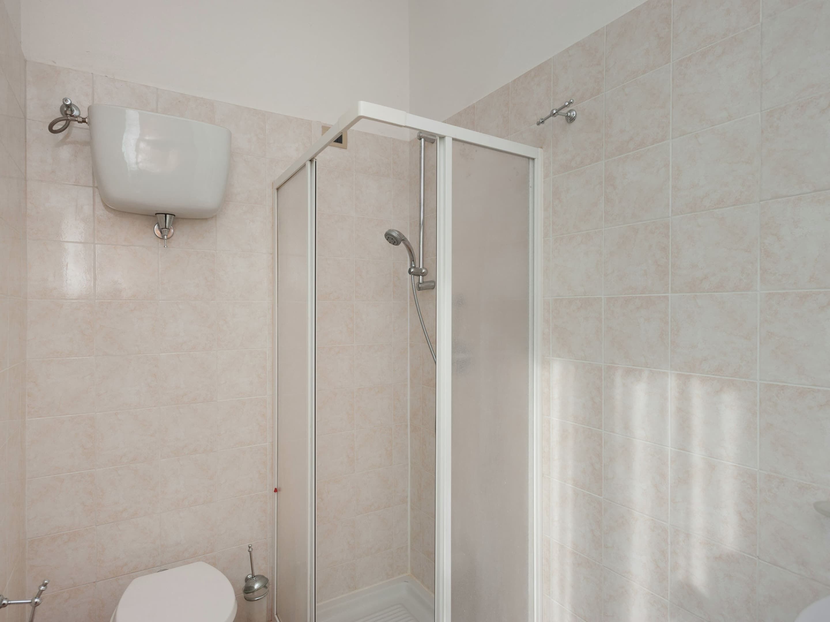 A bathroom with a shower, toilet, and sink.