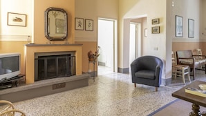 A spacious living room with a fireplace, a television, and a comfortable seating area.