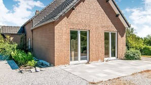 A modern house with a brick exterior, large glass windows, and a sloped roof. - Enticing Holiday Home in Treignes near Forest (Viroinval)