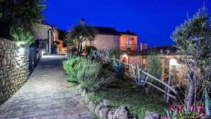 A stone pathway leading to a stone building with a wooden fence and greenery. - Belvilla by Oyo Il Vettore nei Monti Sibillini (Monte San Martino)