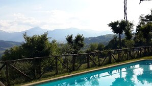 A swimming pool with a view of mountains and trees. - Belvilla by Oyo Il Vettore nei Monti Sibillini (Monte San Martino)
