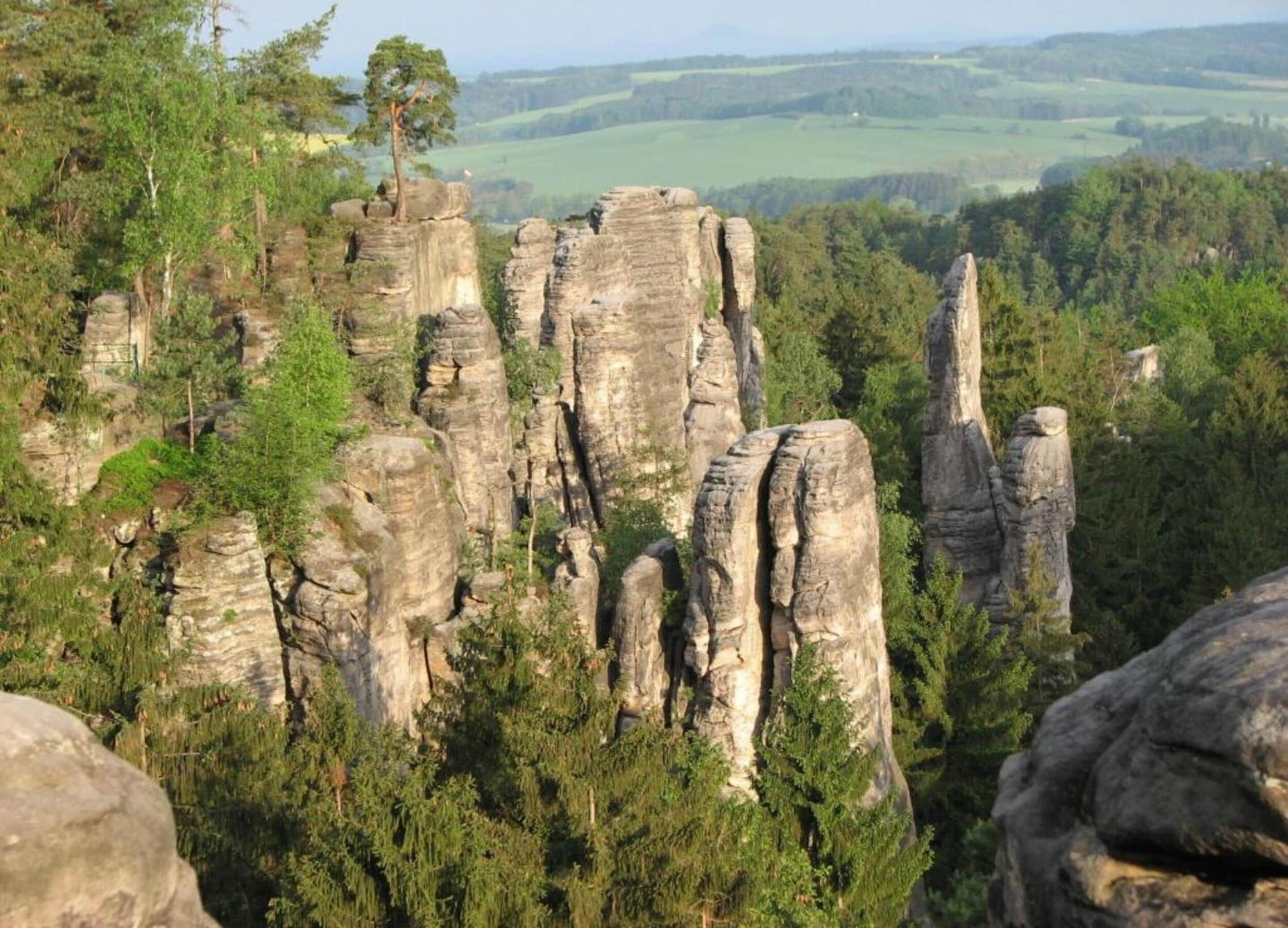 Un paysage caractérisé par d’imposantes formations rocheuses, entourées d’une forêt dense.