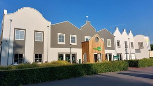 Een modern hotel met een uniek architectonisch ontwerp, met een centrale houten constructie waarop 'Hotel' staat.