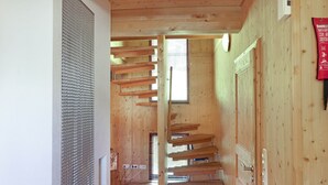 A wooden staircase leading to a second floor with a window at the top.