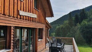 A wooden building with a sign reading "HARBIEJA" and a deck with outdoor furniture.