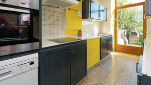 Cucina con forno Whirlpool, lavastoviglie Siemens e pannello di fondo giallo.