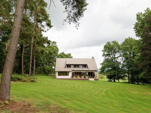 A house with a sloped roof, a front porch, and a well-maintained lawn. - Tenneville Villa With Sauna (Tenneville)