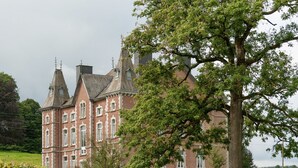 A large, historic building with multiple towers and a prominent tree in the foreground. - Tenneville Villa With Sauna (Tenneville)